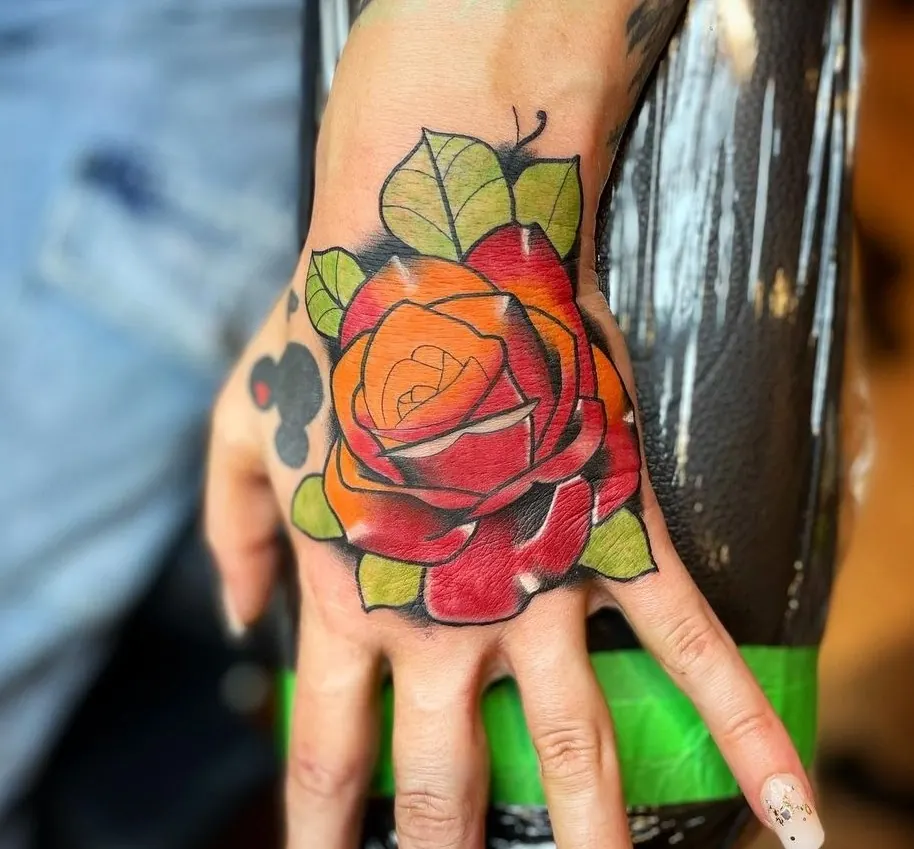 Colourful rose tattoo on a hand