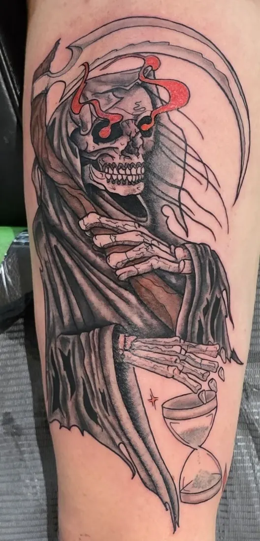 Reaper with an hourglass tattoo on an arm